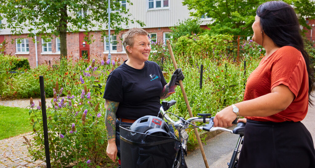 Miljövärd i samtal med hyresgäst med cykel.