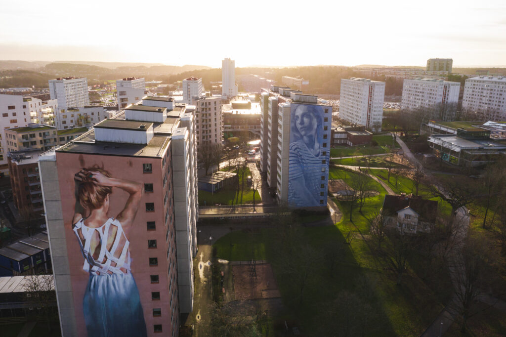 Flygbild över Mandolingatan med fasadmålningar av unga kvinnor.