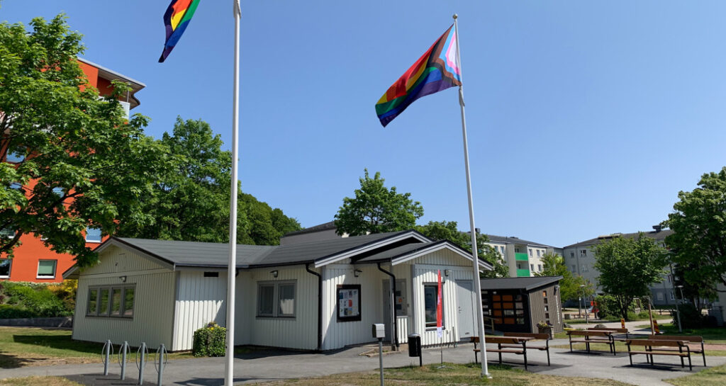 Hissade Pride-flaggor framför samlingslokal i Backa.