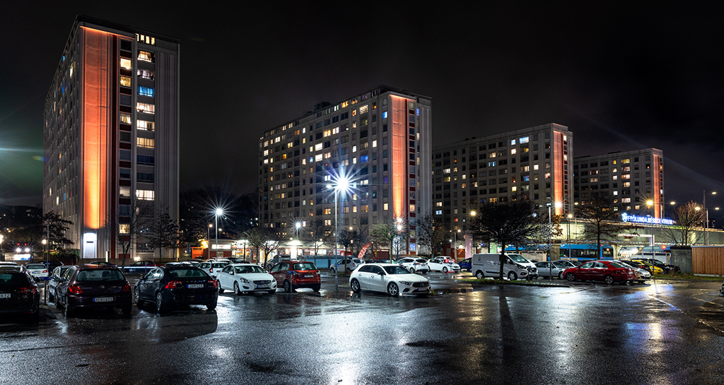 Bild på hus i skymning med orange belysning, Näverlursgatan vid Frölunda Torg