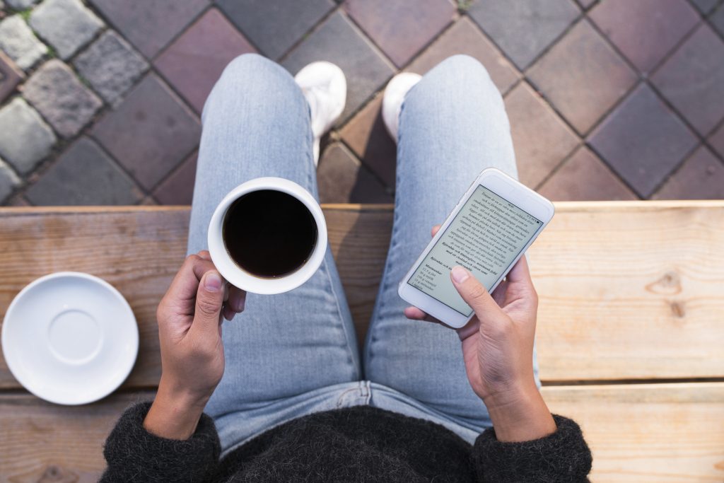 Kvinna med kaffe och smartphone.