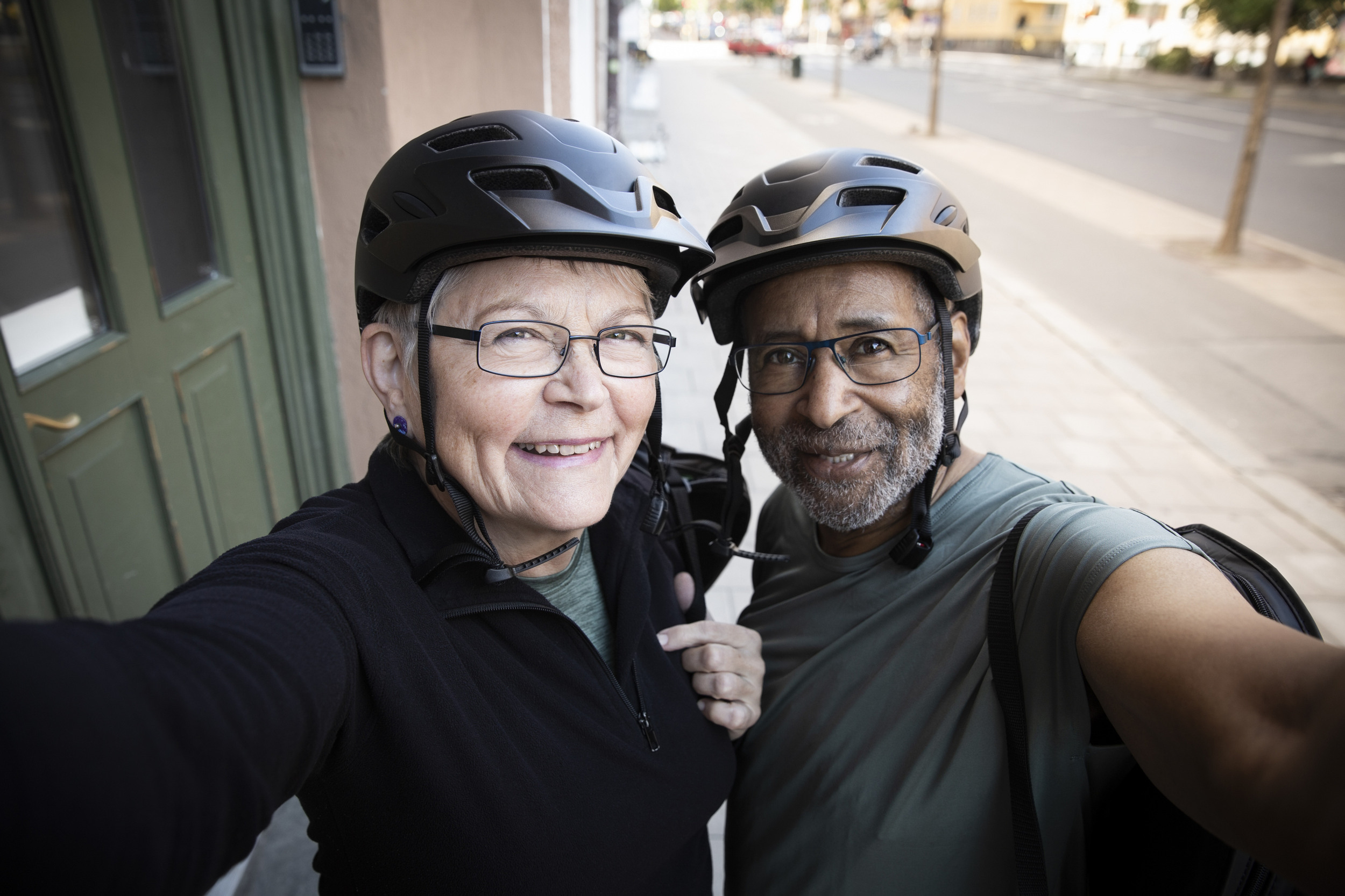 Glatt par tar en selfie utanför ett hus.