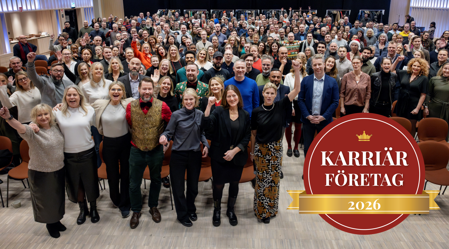 En gruppbild på hundratals medarbetare och badgen "Karriärföretag 2026"
