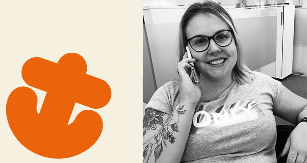 Ett orange ankare och en glad tjej med mobiltelefon