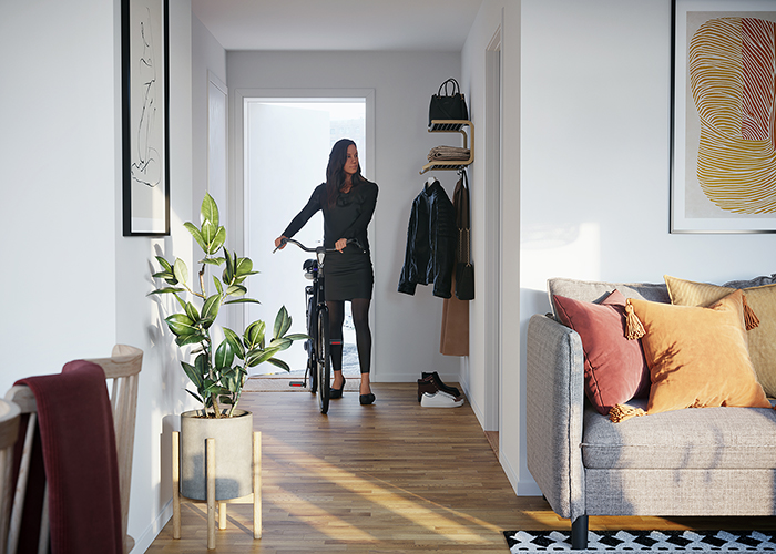 Kvinna leder in cykel i en lägenhet