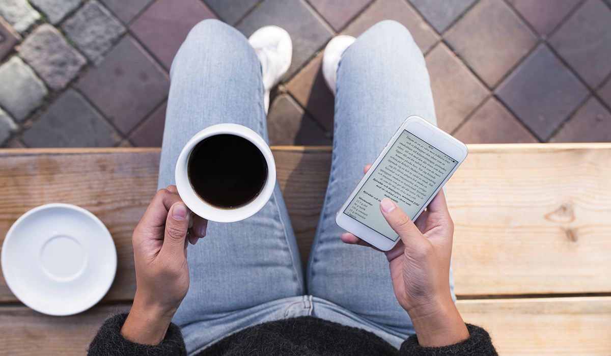 Kvinna med kaffe och smartphone